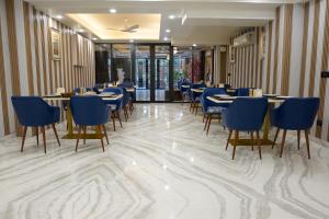 a dining room with tables and blue chairs at Five Palms Hotel in Gurgaon