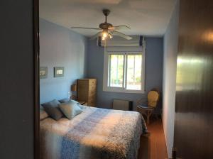 a bedroom with a bed and a ceiling fan at Coma-ruga in Comarruga
