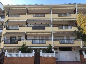 a large apartment building with balconies and a fence at Coma-ruga in Comarruga