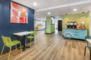 a lobby with a table and chairs and a counter at Spark By Hilton Roanoke Airport in Roanoke