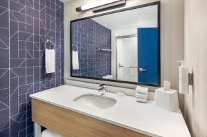 a bathroom with a sink and a mirror at Spark By Hilton Roanoke Airport in Roanoke +53 photos
