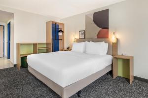 a large white bed in a hotel room at Spark By Hilton Roanoke Airport in Roanoke