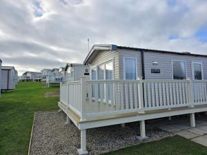 a mobile home with a white railing on a yard at Pine Ridge B6 in Reighton