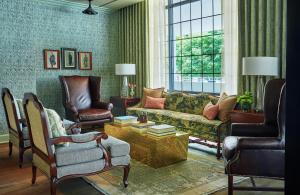 a living room with a couch and two chairs at Graduate by Hilton Charlottesville in Charlottesville