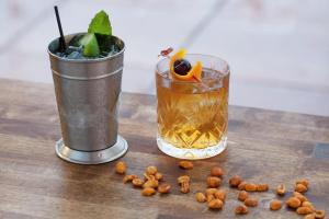 two drinks on a wooden table with walnuts on the table at Graduate by Hilton Charlottesville in Charlottesville
