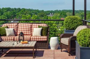 a patio with a couch and two chairs and a table at Graduate by Hilton Charlottesville in Charlottesville +72 photos