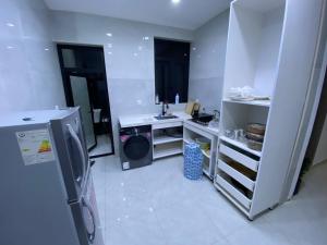 a white kitchen with a sink and a washing machine at Cartier in Baghdād