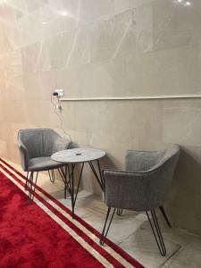 two chairs and a table in a room at Cartier in Baghdād