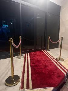 a red rug on a floor next to two poles at Cartier in Baghdād