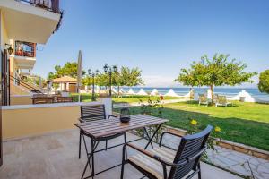 a patio with a table and chairs and the ocean at Thalassa Apartments & Studios in Kavos