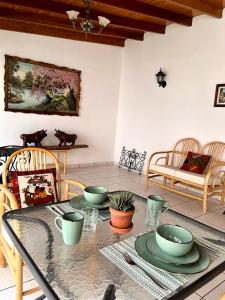a dining room with a table with plates and bowls on it at Casa Cerezos in Ica