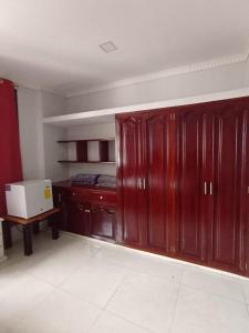 a room with wooden cabinets and a bed in it at Mimo Suits y Rooms in Machala