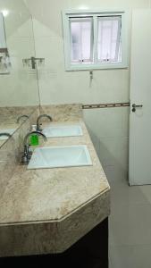 a kitchen counter with two sinks and a refrigerator at Private Suite Confortable Stay in Florianópolis