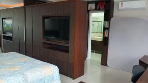 a bedroom with a flat screen tv and a bed at Private Suite Confortable Stay in Florianópolis +8 photos