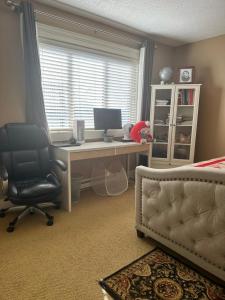 a bedroom with a desk with a computer and a chair at Bright Private Room in Echo Valley Home in Victoria