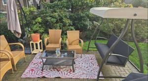 a group of chairs and a table and an umbrella at Bright Private Room in Echo Valley Home in Victoria +4 photos