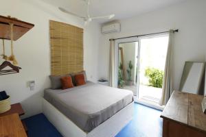 a bedroom with a bed and a large window at Suku'un in Brisas de Zicatela