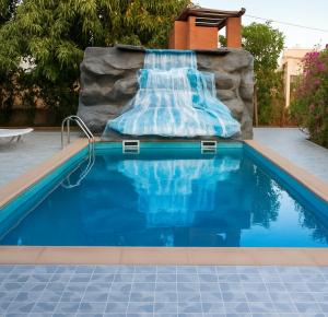 a pool with a reclining chair next to a swimming pool at Ecogîte Dégg-Jàmm in Mbour