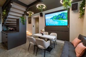 a dining room with a large screen in the wall at R2 apartman in Kecskemét