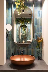 a large wooden tub in a bathroom with a mirror at R2 apartman in Kecskemét