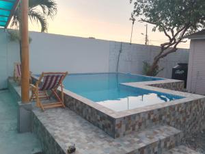 a swimming pool with a chair in a brick retaining wall at Kame House in Castelnovo +4 photos