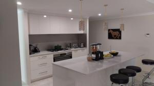 a kitchen with white cabinets and a white counter top at Piara Sojourn in Perth +15 photos