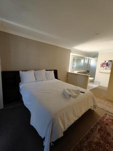 a bedroom with a large bed with two towels on it at Piara Sojourn in Perth