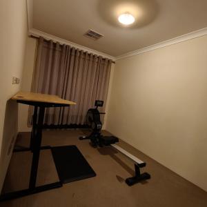a room with a table and a chair in front of a window at Piara Sojourn in Perth