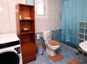 a bathroom with a toilet and a washing machine at AnastasiaSunsetView in Souda +18 photos