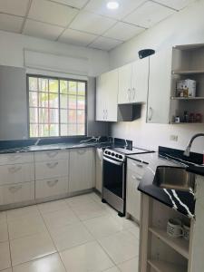 a kitchen with white cabinets and a stove top oven at Casa Yasmin in San Mateo
