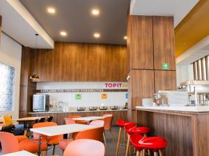 a restaurant with tables and chairs and a counter at Tru By Hilton Puebla Angelopolis in Puebla
