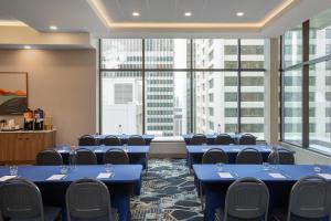 a conference room with blue tables and chairs and large windows at Hampton Inn By Hilton Calgary Downtown in Calgary