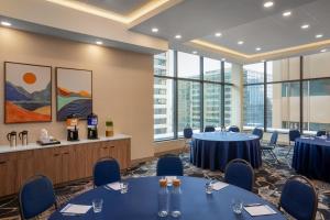 a conference room with tables and chairs and windows at Hampton Inn By Hilton Calgary Downtown in Calgary