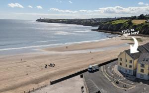 an aerial view of a beach with a building at Charming Beachfront Apartments, Best Sea Views in Tramore in Tramore