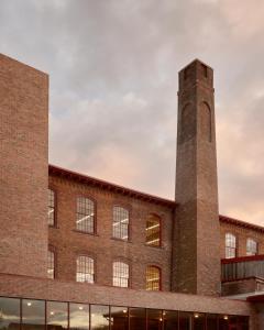 a brick building with a clock tower on top at Pocketbook Hotel and Baths in Hudson