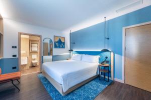 a bedroom with a large bed with a blue wall at Hilton Garden Inn Rome Colosseum in Rome +124 photos