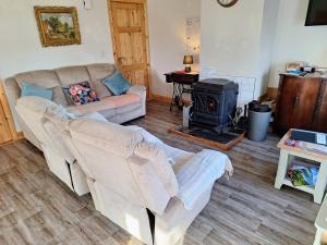 a living room with a couch and a wood stove at Lough Lea House, Bunnamuca in Strokestown