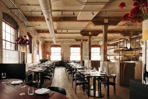 a dining room with tables and chairs and windows at Pocketbook Hotel and Baths in Hudson