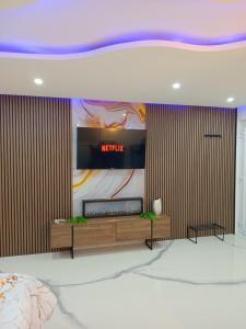 a living room with a television on a wall at Jacuzzi Apartman in Karuše