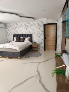 a bedroom with a bed and a stone wall at Jacuzzi Apartman in Karuše