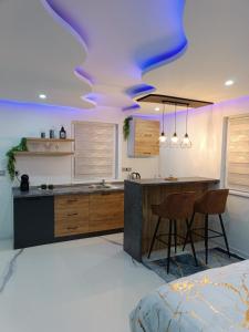 a kitchen with a purple ceiling with a kitchen island at Jacuzzi Apartman in Karuše