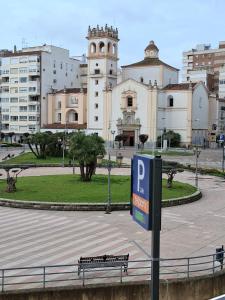 a parking sign in front of a park with a building at San Atón apartamentos in Badajoz