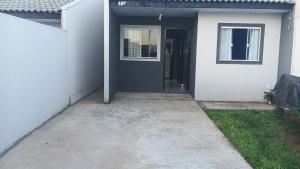 a door to a white house with a driveway at Casa inteira in Ponta Grossa