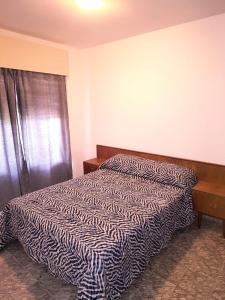 a bedroom with a black and white comforter on a bed at Alojamiento casa amueblada in Villa María
