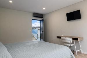 a bedroom with a bed and a desk and a window at Ermida Vista Douro in Baião