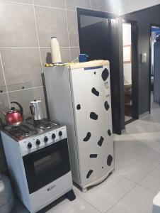 a refrigerator and a stove in a kitchen at Casa inteira in Ponta Grossa