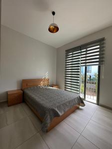 a bedroom with a bed and a large window at Kıbrıs Town House Menekşe in Aglantzia +48 photos