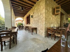 a restaurant with tables and chairs and a stone wall at Kıbrıs Town House Menekşe in Aglantzia