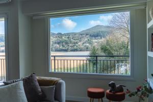 a living room with a large window looking out at a lake at El Secreto de Sandindere in Busturia