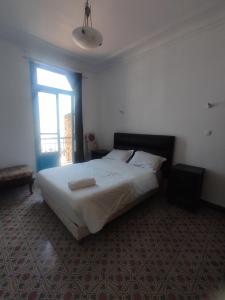 a bedroom with a large bed with a window at Appartement 3 pièces in LʼAgha
